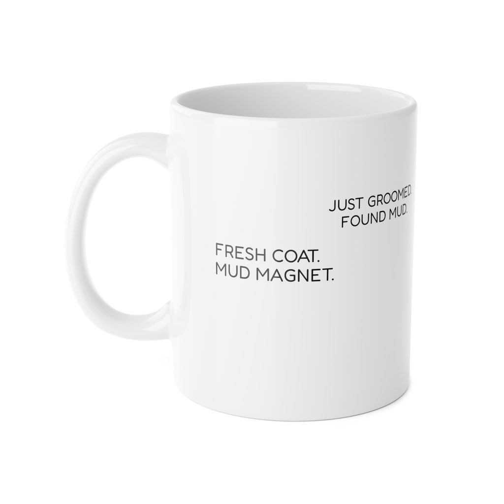 White ceramic mug showing the wraparound phrases ‘Just Groomed. Found Mud.’ and ‘Fresh Coat. Mud Magnet.’